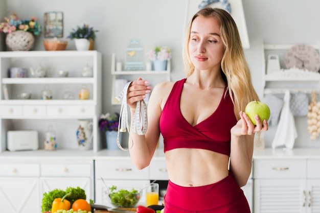 Dieetconcept met sportieve vrouw in keuken