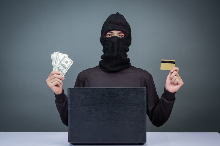 Gratis Foto dieven houden creditcards vast met behulp van een laptop voor het hacken van wachtwoorden.