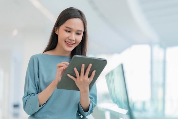 Digitale nomade levensstijl aziatische vrouwelijke vrouw hand met behulp van tablet werken wit blijf buiten met natuurlijke lichtaziatische vrouwelijke jonge vrouw die lacht vrolijke vrijheid positieve glimlach staande hand houden tablet