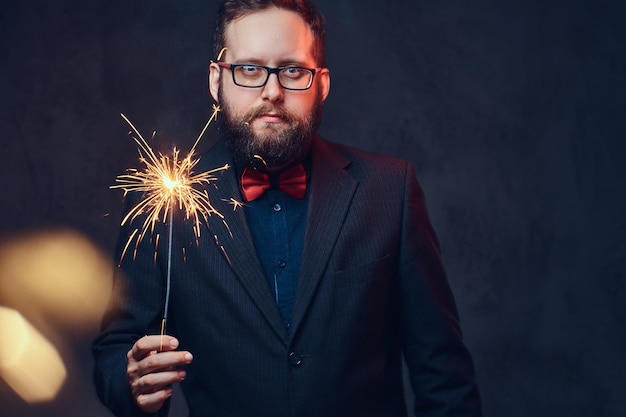 Dikke man in bril gekleed in een overhemd met vlinderdas drinkt ambachtelijk bier uit een fles.