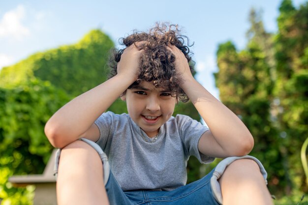 Gratis foto dillema de jongen houdt zijn handen bij het hoofd en denkt ergens aan