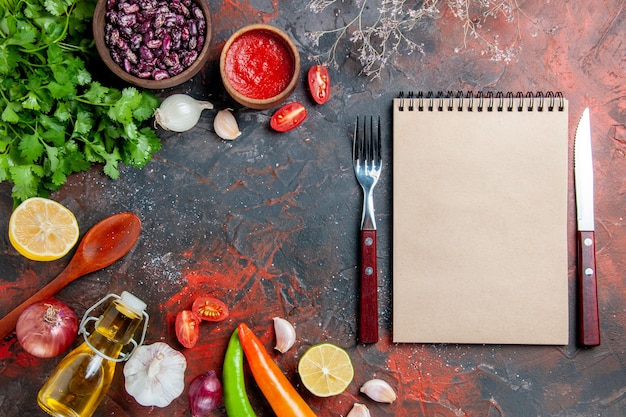 Gratis foto diner voorbereiding met een bos van groene olie fles knoflook en lepel op gemengde kleurentafel