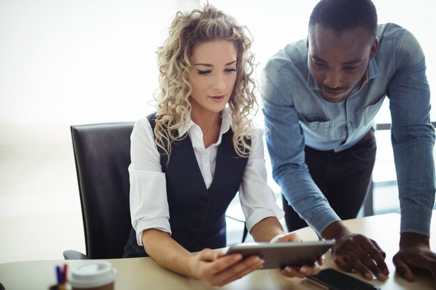 Directeuren die over digitale tablet bespreken