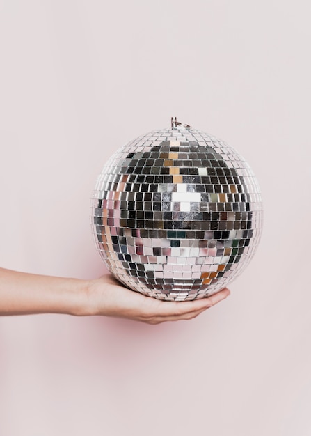 Disco bal hand gehouden op nieuwjaarsfeest