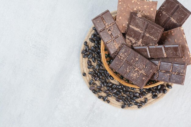 Diverse chocoladerepen in houten mand met snoepjes. Hoge kwaliteit foto