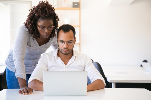 Diverse collega's die op presentatie op computer letten