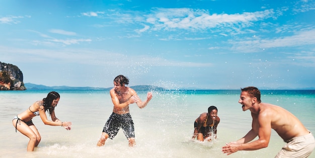 Diverse groep vrienden die in het strandwater spelen