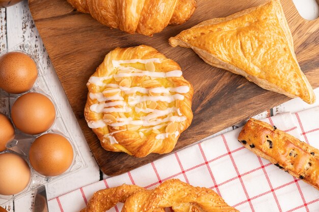 Diverse soorten brood en eieren op rode witte doek.