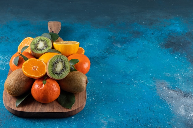 Diverse soorten vers fruit geplaatst op een houten snijplank Premium Foto