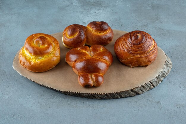 Diverse zoete gebakjes op houten stuk.