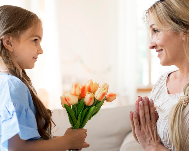 Gratis foto dochter die moederboeket tulpen geeft