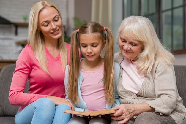 Dochter en familie zittend op een bank en lees een boek