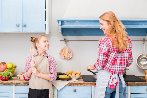 Dochter en haar moeder die voedsel in de keuken koken