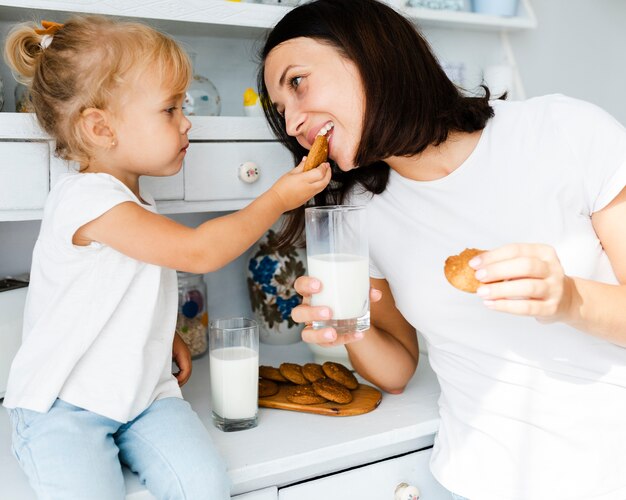 Dochter en moeder die koekjes eten