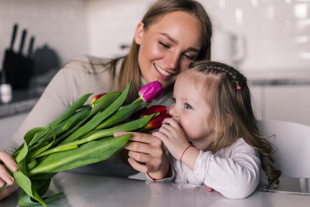 Dochter feliciteert moeder en geeft haar bloemen tulpen