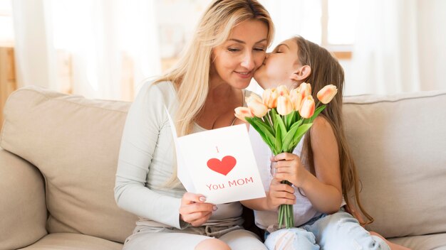 Dochter verrassende moeder met tulpen en kaart