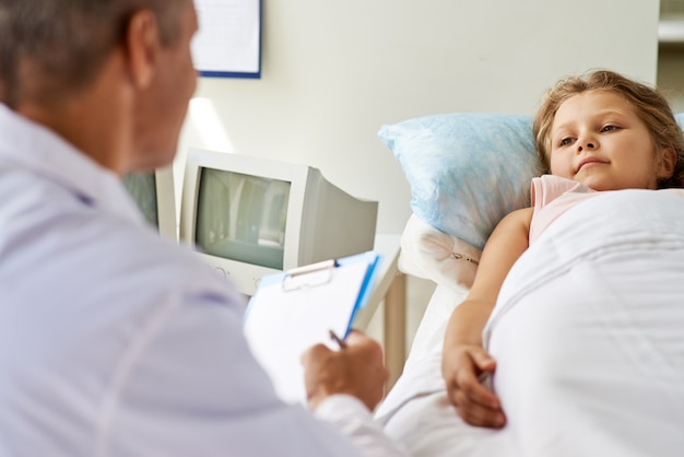 Doctor in gesprek met zijn kleine patiënt