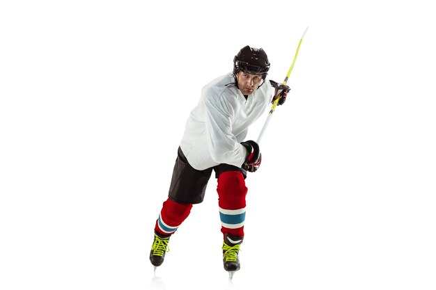 Doelwit. Jonge mannelijke hockeyspeler met de stok op ijsbaan en witte muur. Sportman uitrusting dragen en helm oefenen. Concept van sport, gezonde levensstijl, beweging, beweging, actie.