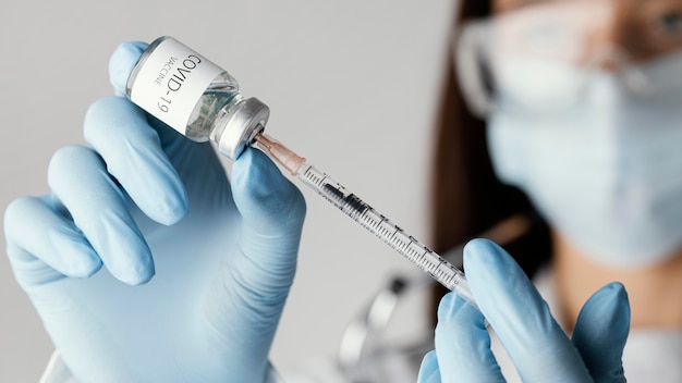 Gratis foto dokter die een covid-19-vaccin voorbereidt