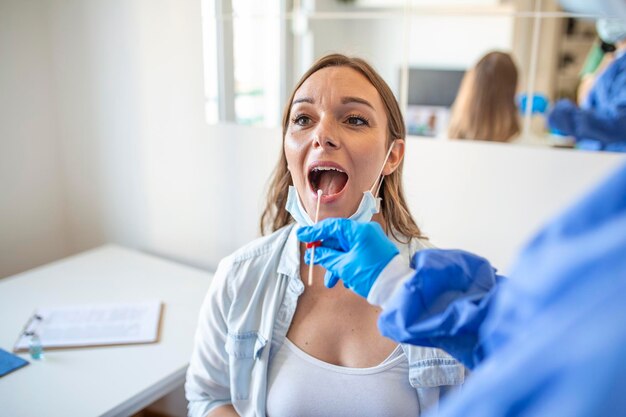 Dokter die PCR-neusuitstrijkje test van een zwangere vrouw COVID19 vaccinatieconcept