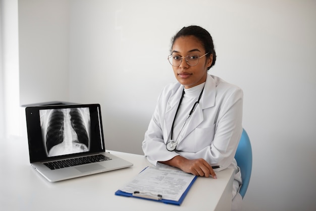 Gratis foto dokter loopt met laptop medium shot