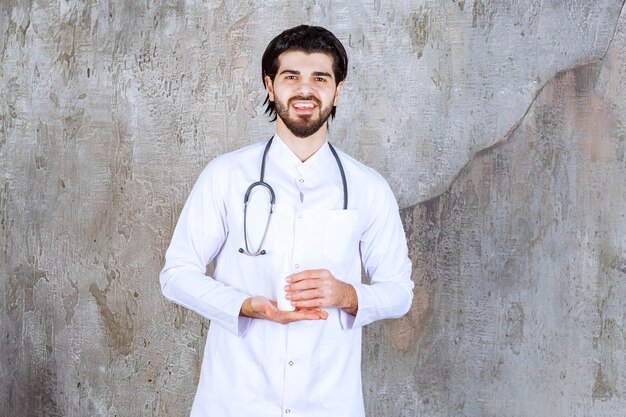 Dokter met een stethoscoop met een witte tube handdesinfecterende spray