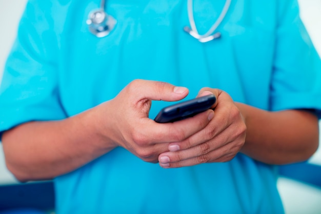 Gratis foto dokter texting op mobiele telefoon