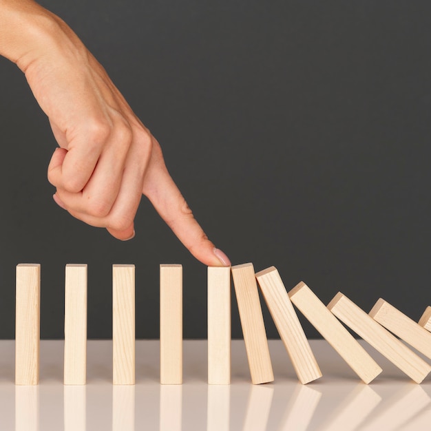 Domino-spel gemaakt met houten stukken die financiële problemen voorstellen
