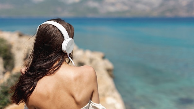 Donkerbruine jonge vrouw die aan muziek luistert