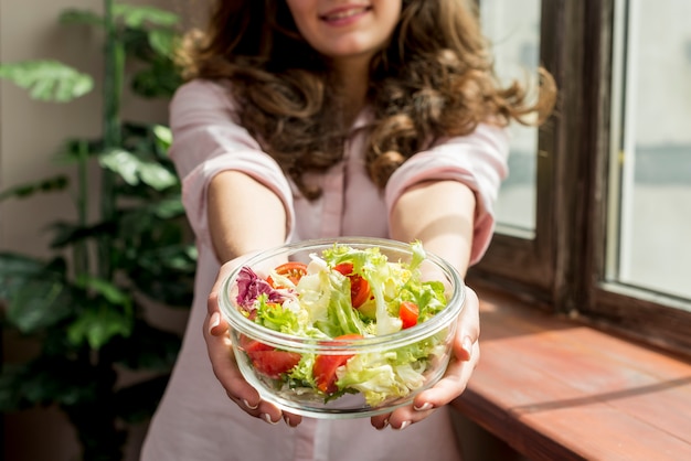 Donkerbruine vrouw die een salade eet