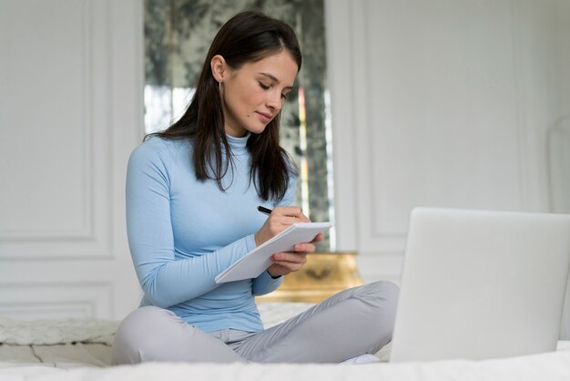 Donkerbruine vrouw die thuis een videogesprek voert