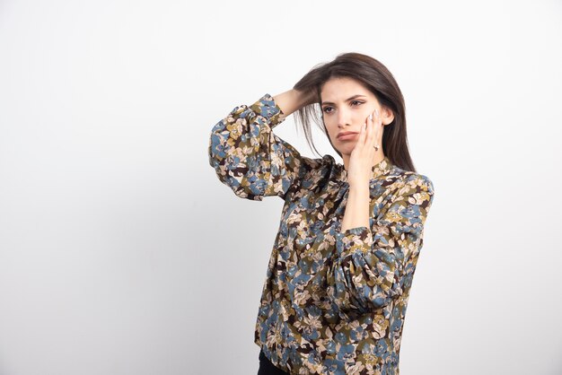 Donkerbruine vrouw die zich op een witte achtergrond bevindt.