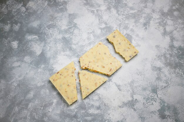 Donkere, witte en melkchocolade stukken op donker. Bovenaanzicht