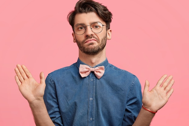 Gratis foto donkerharige man met roze bowtie en denim overhemd