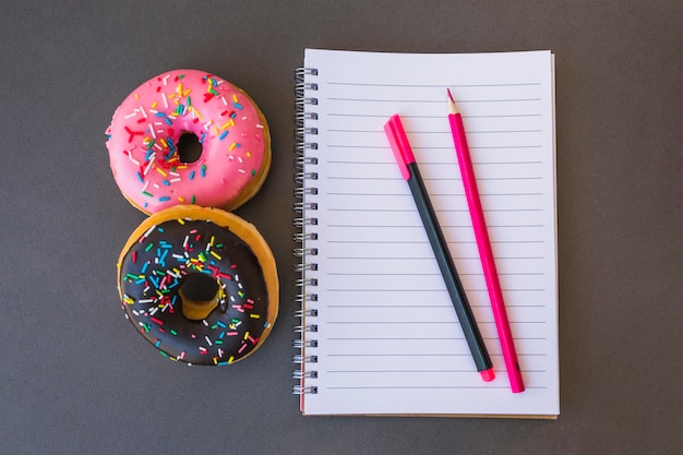 Gratis foto donuts die dichtbij kantoorbehoeften liggen