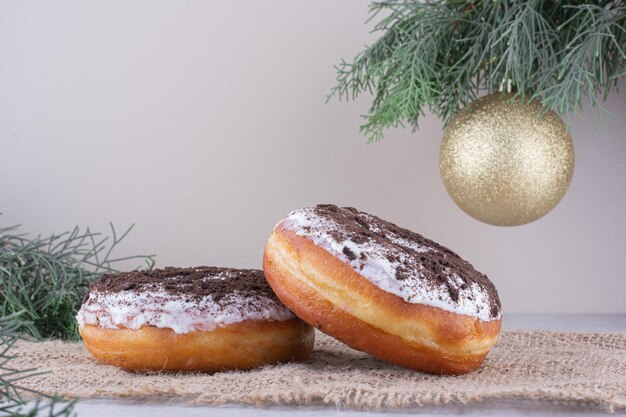 Donuts geplaatst temidden van een decoratief arrangement op een wit oppervlak