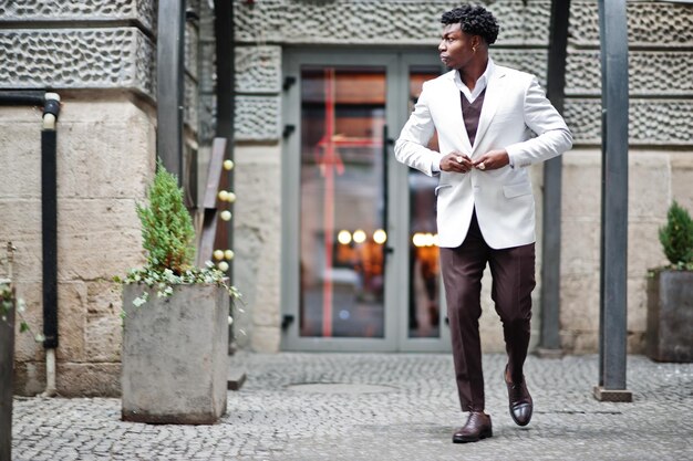 Doordachte jonge knappe Afro-Amerikaanse heer in formalwear Zwarte stijlvolle model man in witte jas