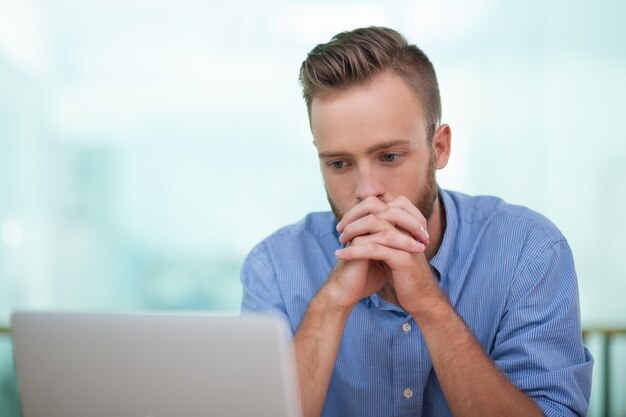 Doordachte zakenman werken op de laptop in het kantoor