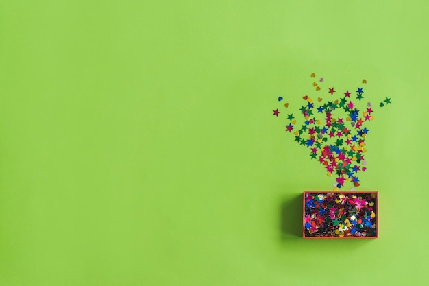 Gratis foto doos met confetti op een groene tafel