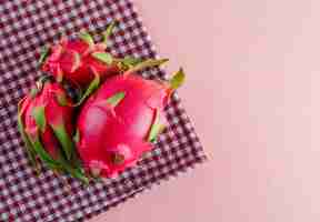 Gratis foto dragon fruit op roze en picknick doek, plat lag.