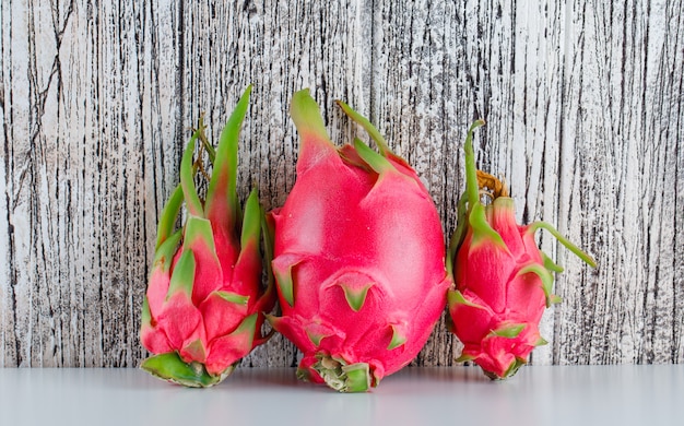 Dragon fruit op witte en houten tafel. zijaanzicht.