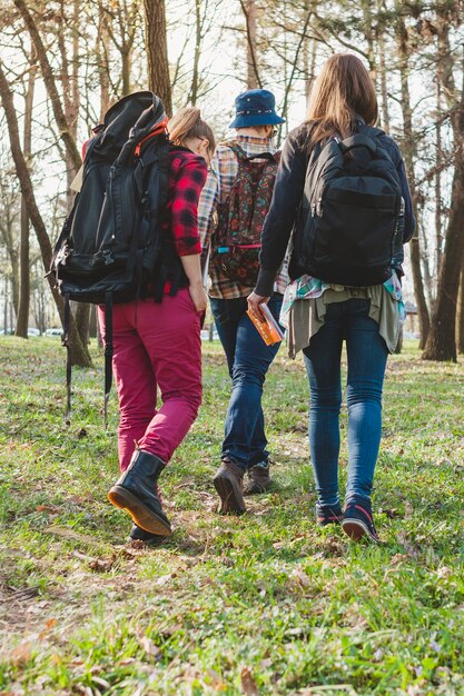 Drie backpackers in boszicht van achteren