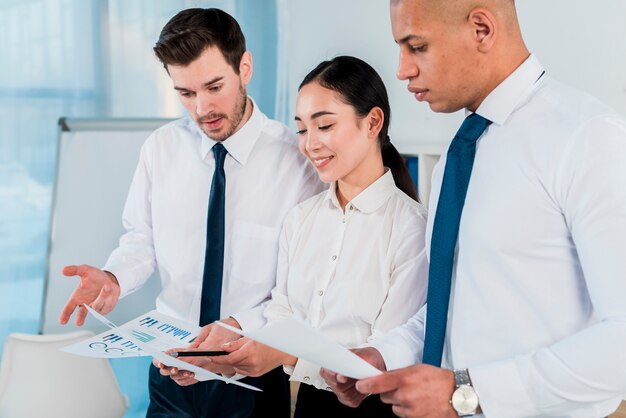 Drie bedrijfsleiders die het businessplan in het bureau bespreken