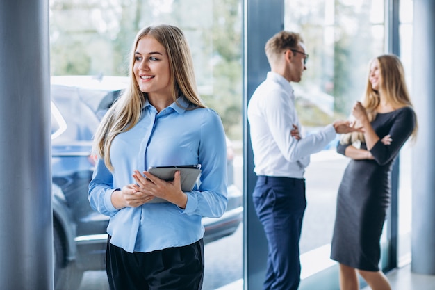 Drie collega's die bij een autotoonzaal werken