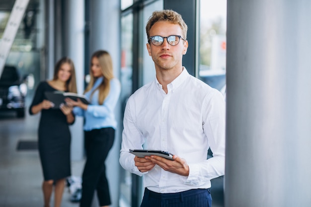 Drie collega's werken in een autosalon.