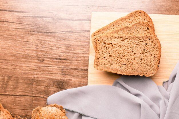 Drie donkere sneetjes brood op een houten tafel