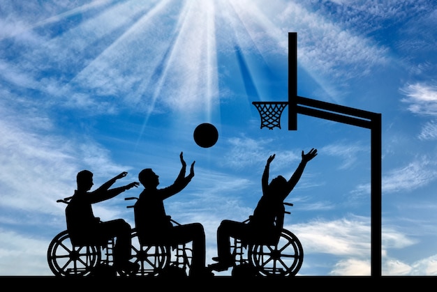 Drie gehandicapten om buiten rolstoelbasketbal te spelen. het concept van sport levensstijl mensen met een handicap