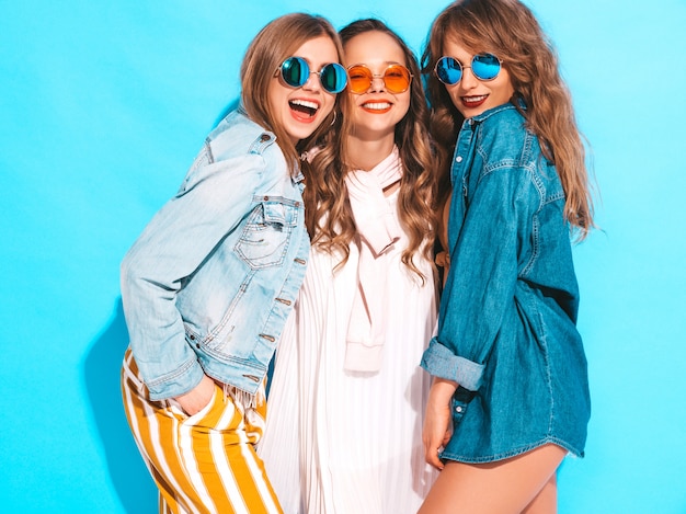 Drie jonge mooie lachende meisjes in trendy zomer casual jurken. Sexy zorgeloze vrouwen poseren. Positieve modellen