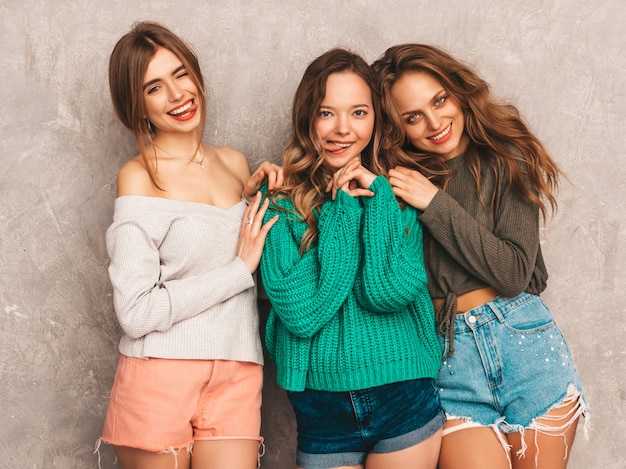 Drie jonge mooie lachende prachtige meisjes in trendy zomerkleren. sexy zorgeloze vrouwen poseren. positieve modellen met plezier in ronde zonnebril