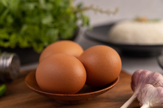 Drie kippeneieren op de plaat met knoflook.